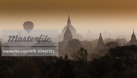 Hot-air balloon floats through the hazy skies of Bagan, Myanmar