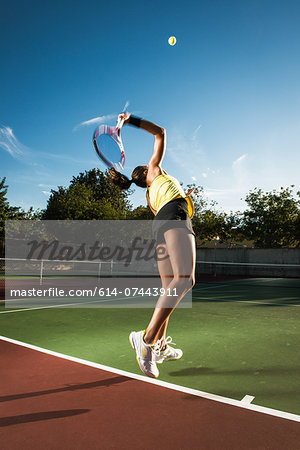 Female tennis player hitting ball