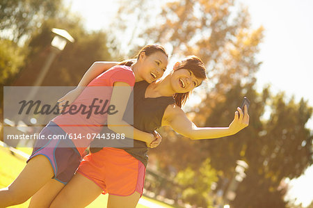 Two young women taking self portrait in park