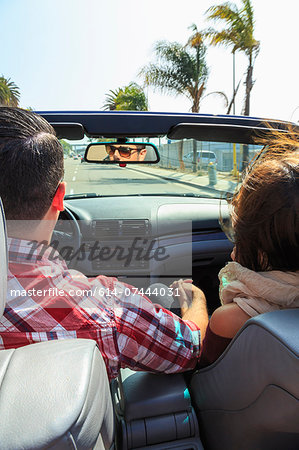 Young couple driving convertible, San Diego, California, USA