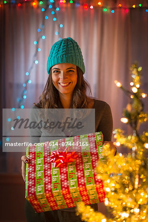 Portrait of young woman holding christmas gift