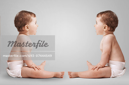 Identical twins looking at each other in studio