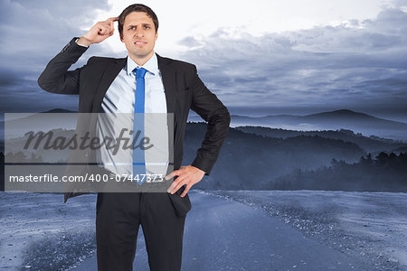 Thinking businessman scratching head against road leading out to the horizon at night