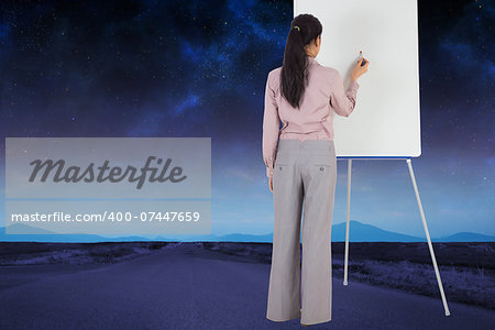 Businesswoman painting on an easel against road leading out to the horizon