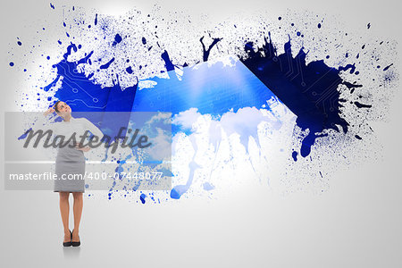 Smiling thoughtful businesswoman against splash on wall revealing cloud computing graphic