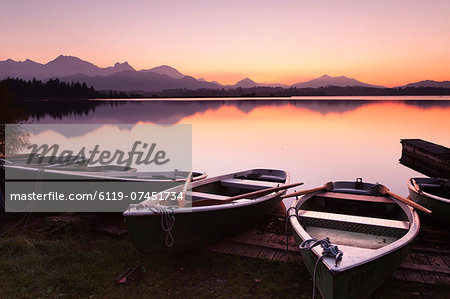 Rowing boats on Hopfensee Lake at sunset, near Fussen, Allgau, Allgau Alps, Bavaria, Germany, Europe