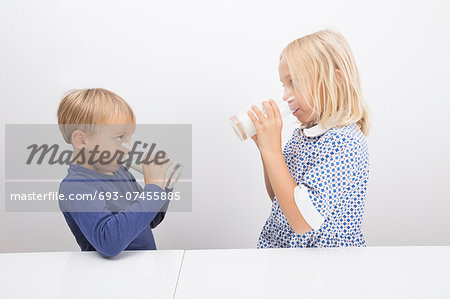 Children drinking milk while looking at each other