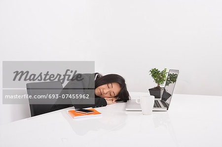 Overworked businesswoman resting at desk in office