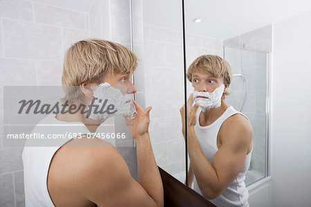 Mid-adult man applying shaving cream in bathroom