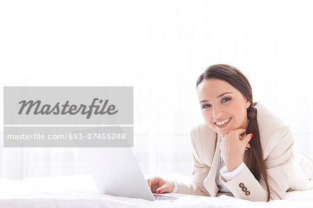 Portrait of beautiful businesswoman using laptop in hotel