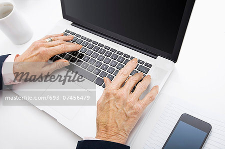 Senior businesswoman using laptop at office desk