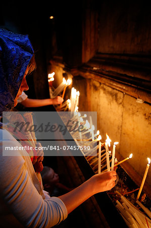 Pilgrims lighting candles in the Holy Sepulchre Church, Jerusalem, Israel, Middle East