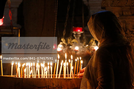 Pilgrim lighting candles in the Holy Sepulchre Church, Jerusalem, Israel, Middle East
