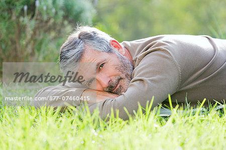 Mature man laying on the grass