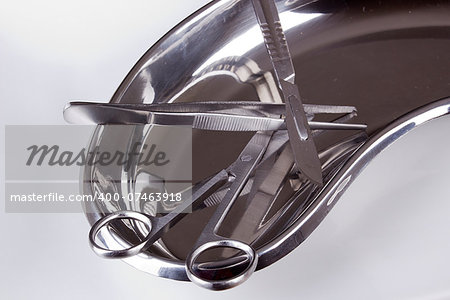 Surgical instruments in kidney tray. Medical equipment.