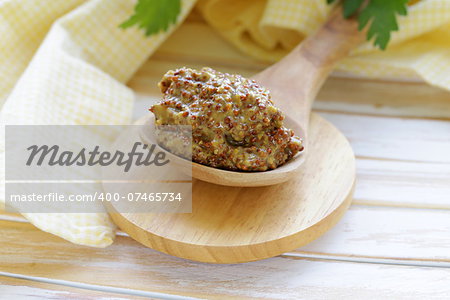 Traditional dijon mustard in a wooden spoon