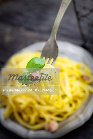 Italian cooking. Pasta spaghetti carbonara with ham, eggs and basil