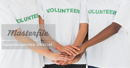 Team of volunteers putting hands together on white background