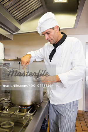 Side view of a concentrated male chef preparing food in the kitchen