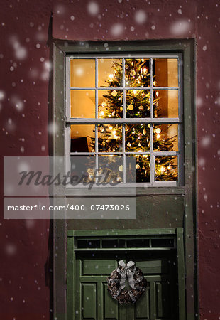 Christmas tree seen outside of a window, snowfall background