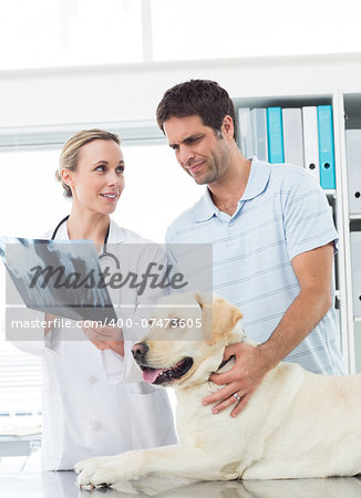 Female vet showing Xray of dog to pet owner in clinic