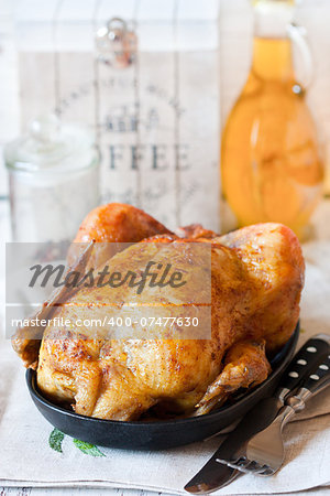 Whole roasted chicken on a pan. Rustic style.