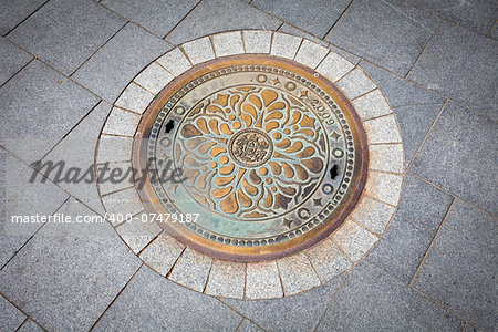 Budapest rusted sewer cap surrounded by pavement granite stones