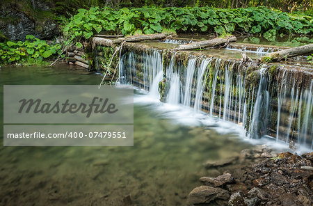 creek and man made waterfall in the forest