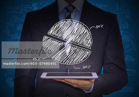 Man in suit holding tablet pc. Above the screen of the tablet are pie chart