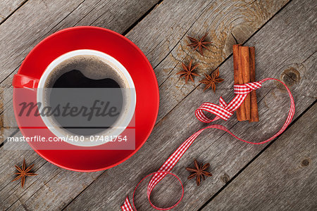 Red coffee cup and spices on wooden table. View from above