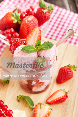 Homemade strawberry ice cream decorated with fresh berries and mint