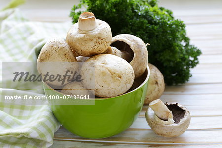 Fresh organic champignon mushrooms on a wooden table