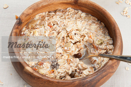 Muesli granola with fruits in wooden bowl close up