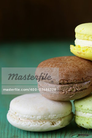 French multicolored macaroons cookies on a vintage wooden background