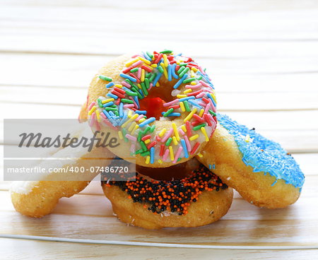 donuts with colorful glaze on the wooden background