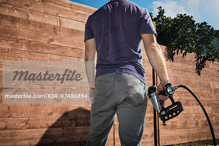 Cropped shot of joiner in backyard in front of new fence