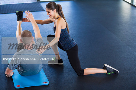 Couple helping each other in gym