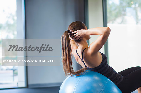 Young woman working out with gym ball