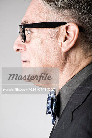 Portrait of senior man wearing bowtie, side view Portrait of senior man wearing bowtie, side view
