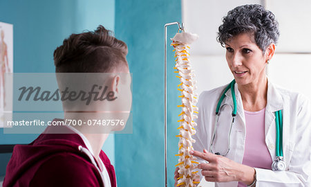 Doctor talking with Teenage Patient in Doctor's Office
