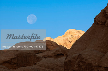 Rock formations and moon in early morning sky, Petra, Jordan