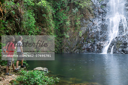 Central America, Belize, Mountain Pine Ridge, Hidden Valley, Butterfly Falls. Two tourists look out over a pool in front of the Butterfly falls (MR) (PR)
