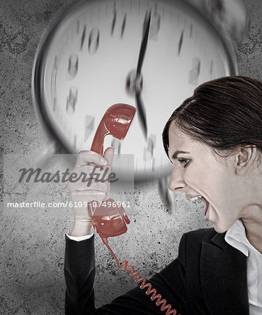 Businesswoman under pressure with deadline shouting down the phone