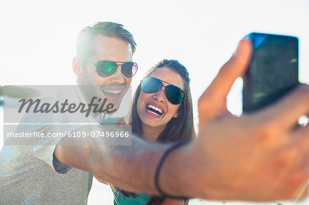 Young couple taking photo with camera on the beach