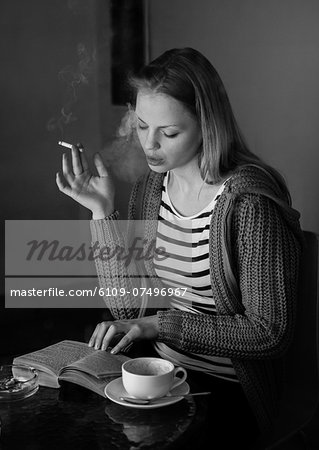 Attractive woman smoking cigarette in black and white