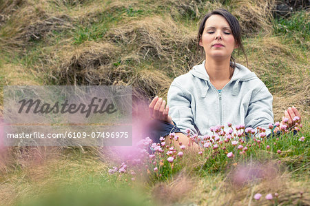 Attractive woman meditating on the grass