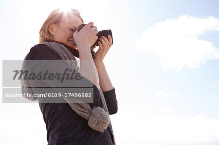 Pretty young woman taking pictures on a sunny day