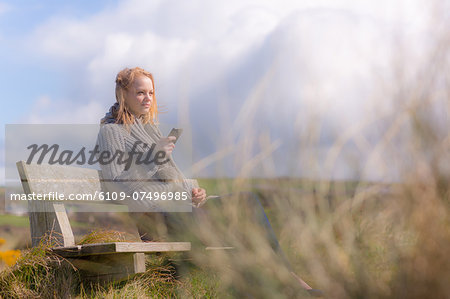 Attractive woman sitting on bench on a sunny day