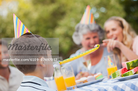Cheerful son celebrating his birthday with his family in the backyard on a summers day