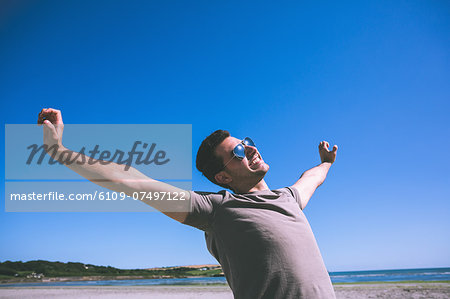 Attractive happy man enjoying the sun on the beach